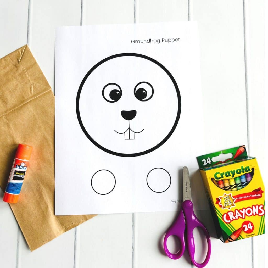groundhog puppet supplies including the groundhog puppet free printable template, crayons, scissors, glue stick and brown paper bag