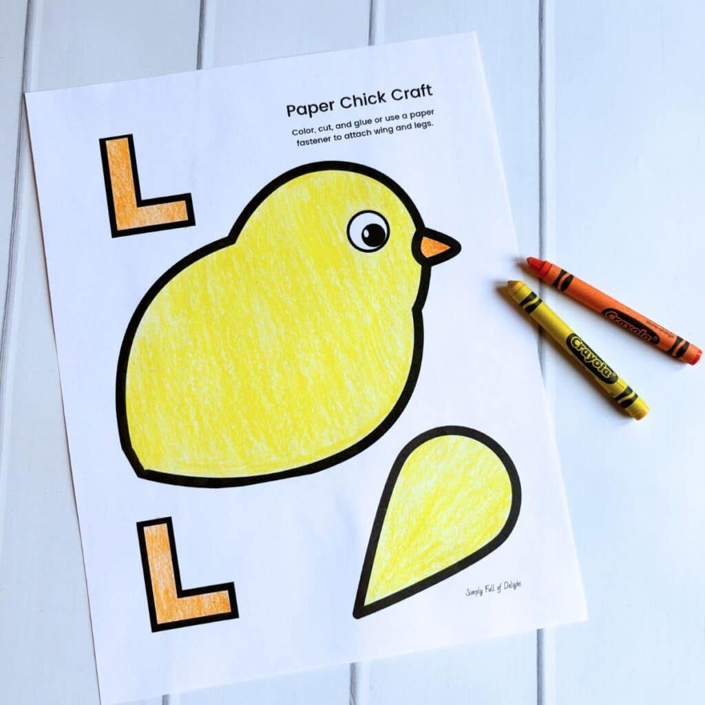 paper chick craft colored with orange and yellow crayons