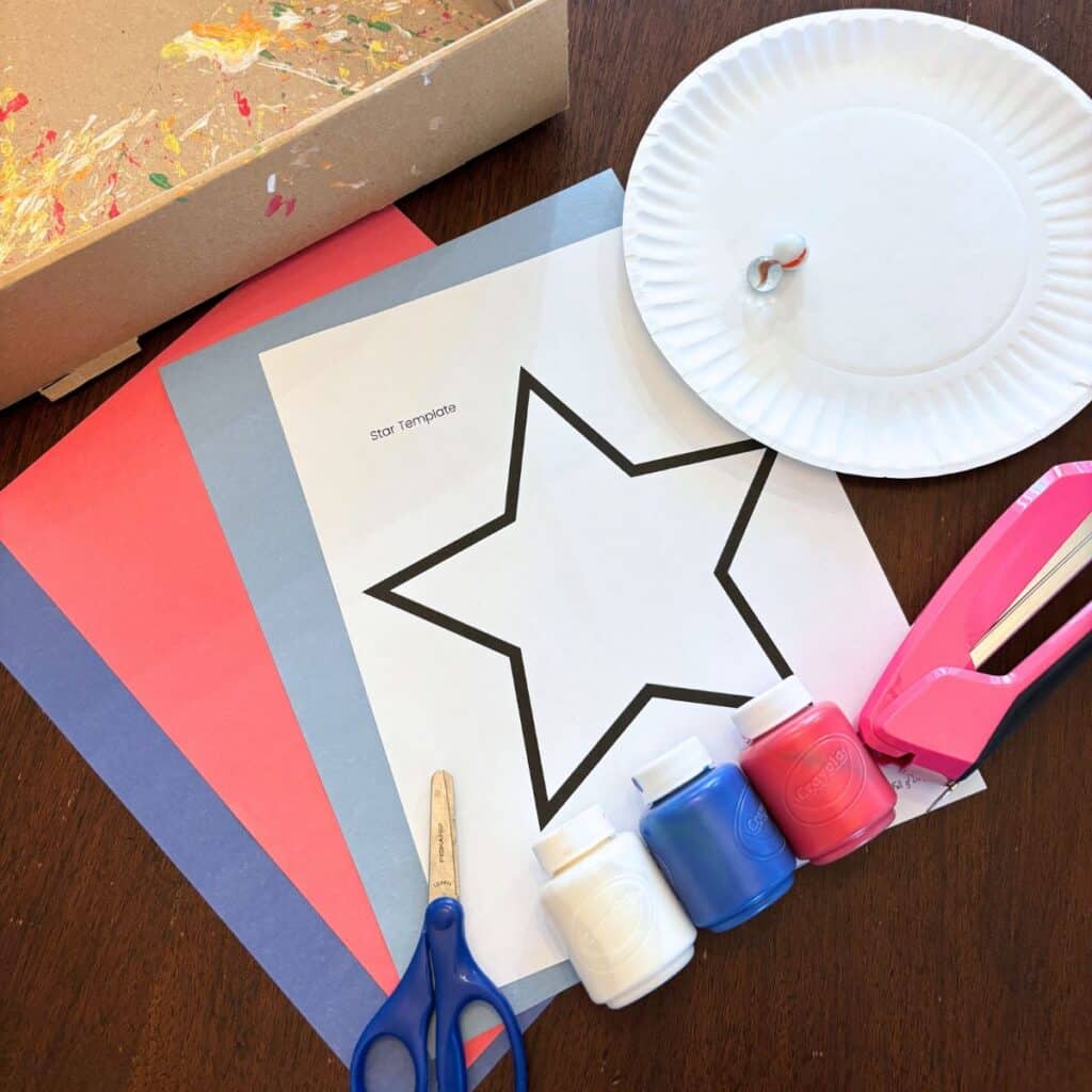 supplies for patriotic star craft:  washable paint, stapler, construction paper, marble, scissors, box, and paper plate