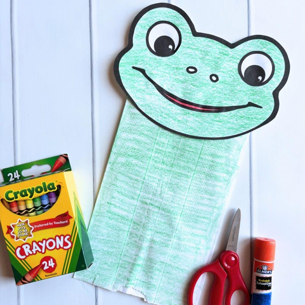 completed frog puppet with crayons